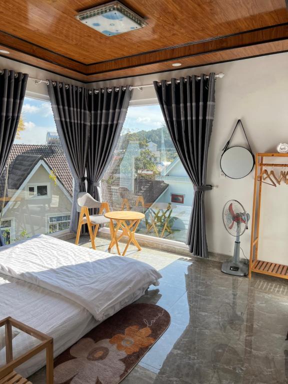 a bedroom with a bed and a large window at MIA Villa Đà Lạt in Khu Chi Lăng