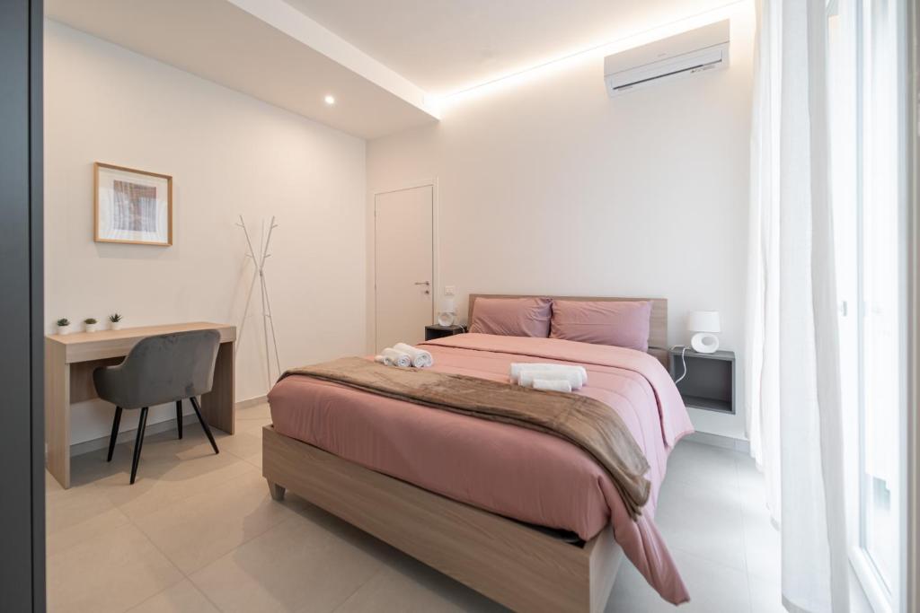 a bedroom with a pink bed and a desk at Alloggio Viola - Gionic Apartments Bologna in Bologna