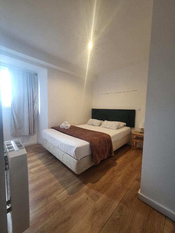 a bedroom with a large bed and a wooden floor at What else guest house in Fátima
