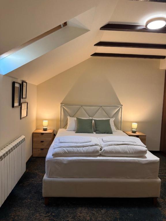 a bedroom with a large white bed with two lamps at Amfora Novi Sad in Pasuljište