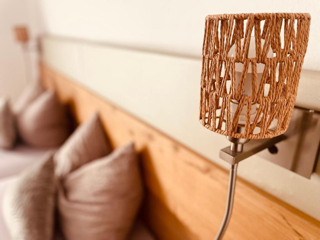a lamp on a table next to a bed at Brandmayerhof in Oberding