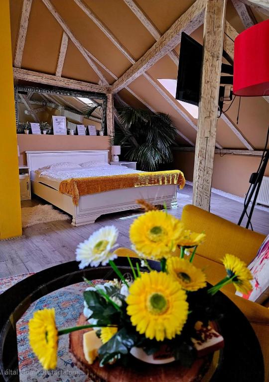 a room with a bed and a table with flowers on it at Laci Lak in Oradea