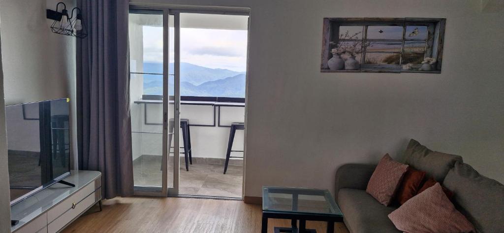 a living room with a couch and a balcony at B661 SilverparkResort -walk up in Bukit Fraser