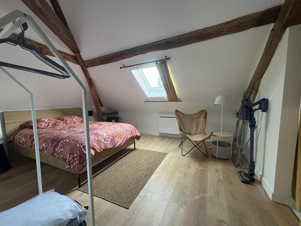 a bedroom with a bed and a chair in a attic at Rustique Chic proche centre-ville in Clermont