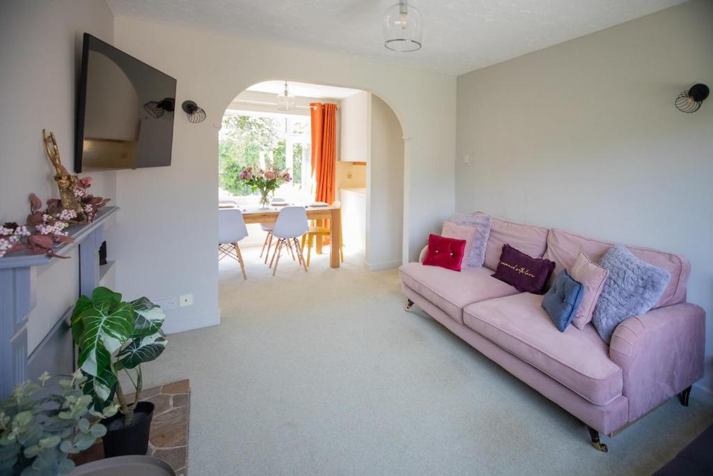 a living room with a pink couch and a table at Hereford Long Term Comfortable Accommodation, 4 bedrooms with Parking in Hereford