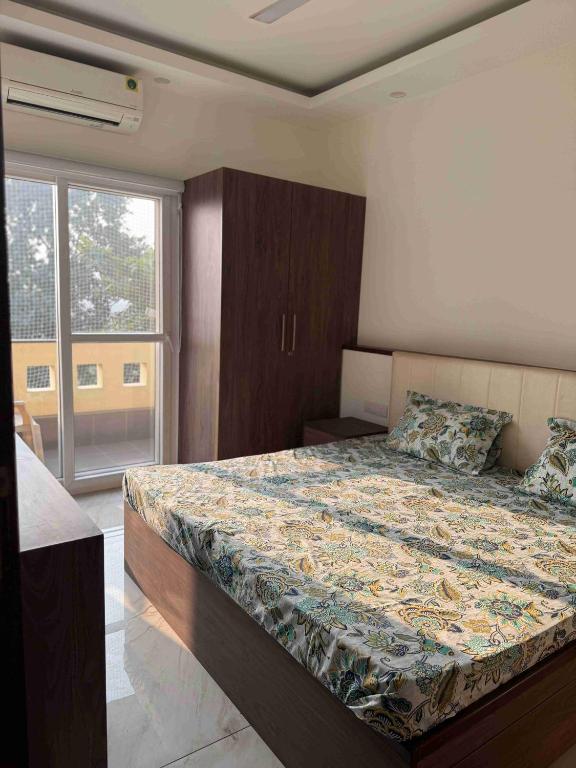 a bedroom with a bed and a large window at Pacation Home Stay in Noida