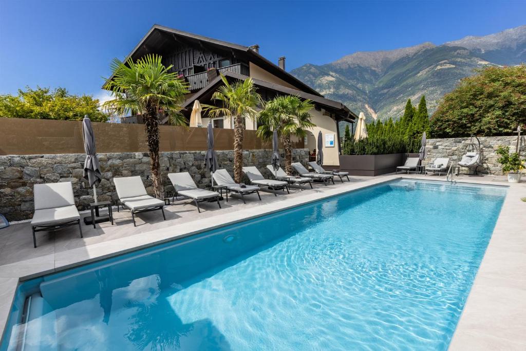 a swimming pool with chairs and a house at bei Martin's in Morter