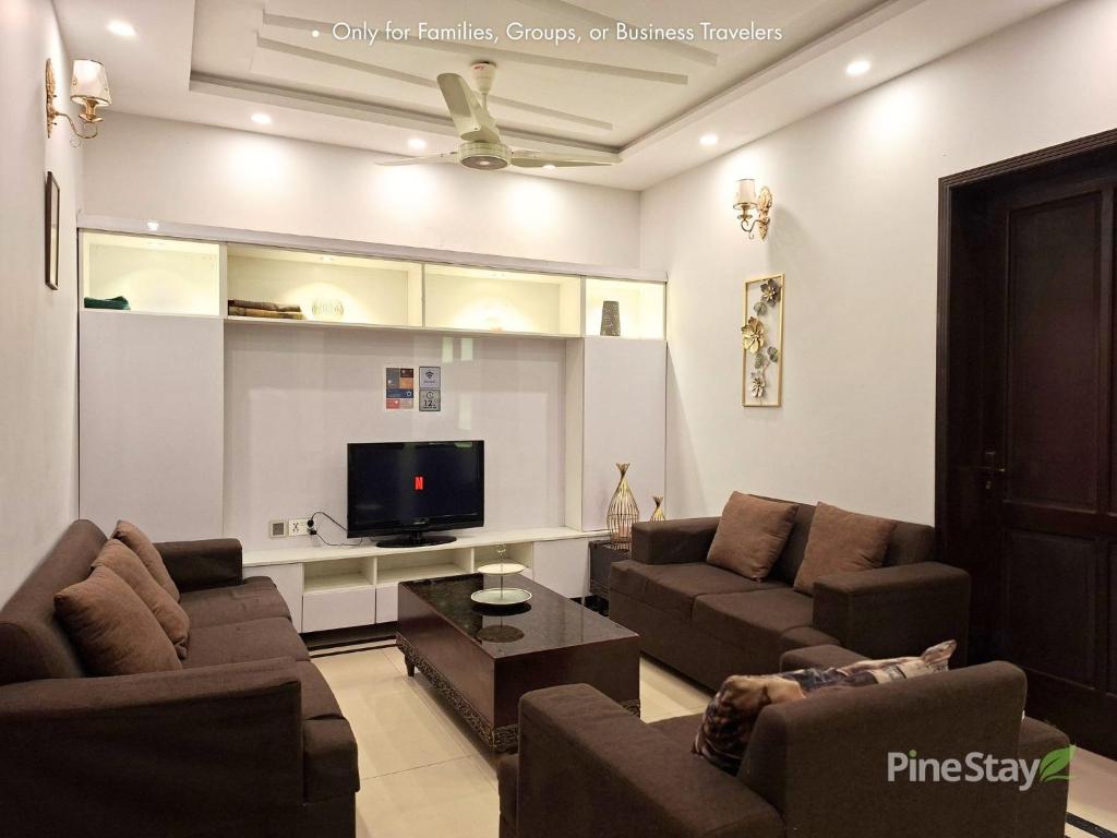 a living room with couches and a flat screen tv at Pine Stay Premium 3 Bedroom Furnished Family Home in Lahore