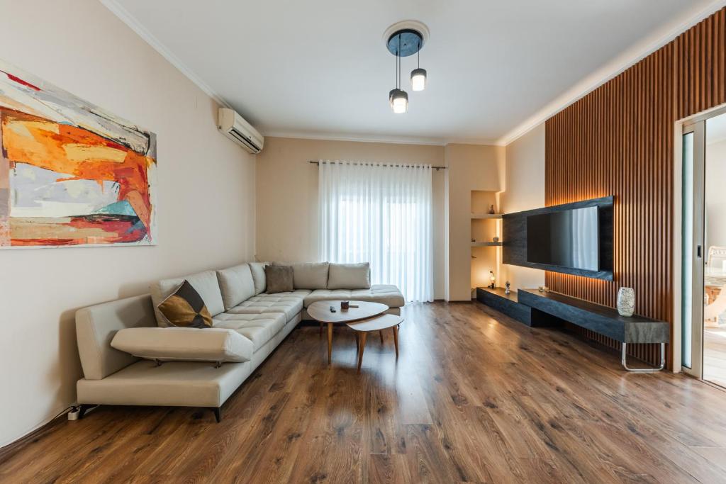 a living room with a couch and a tv at The Old-Clock Apartment by PikHost in Shkodër
