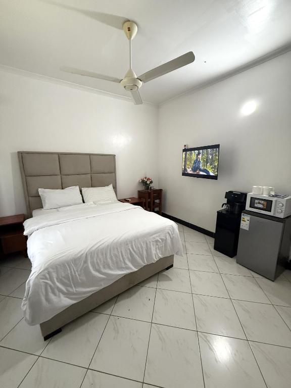 a bedroom with a bed and a ceiling fan at Dana's Room in Dar es Salaam
