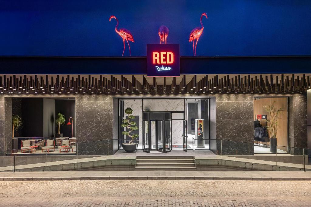 a red sign on the side of a building at Radisson RED Izmir Point Bornova in İzmir