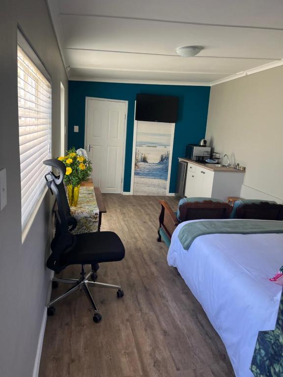 a bedroom with a bed and a desk and a chair at Grace from Above in Malmesbury