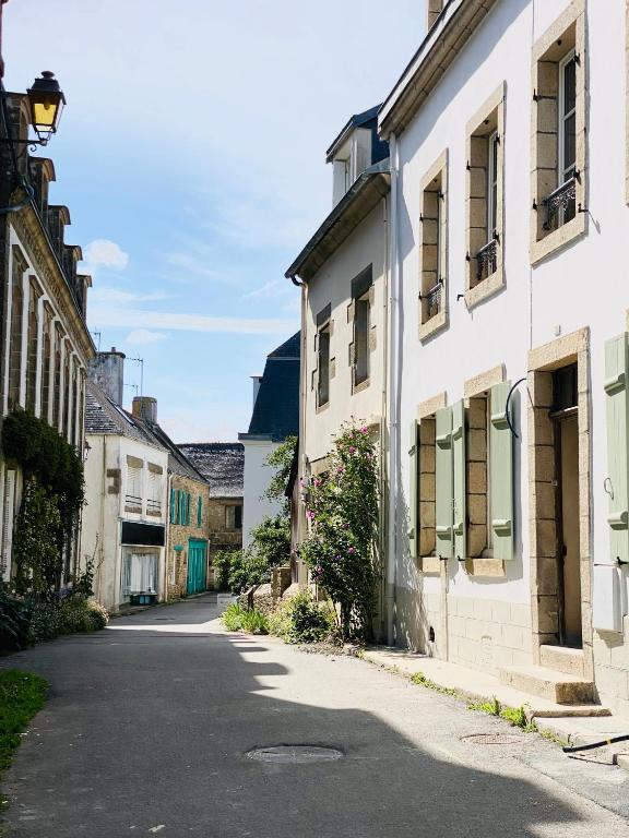 an empty street in a town with white buildings at Les volets verts in Pont-Croix