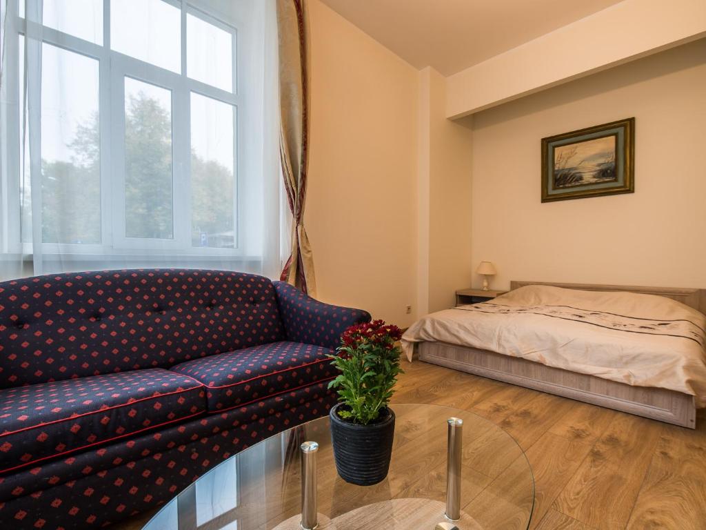 a living room with a couch and a bed at AmberHome in Liepāja