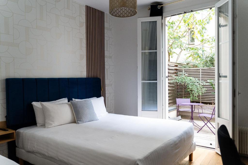 a bedroom with a bed and a sliding glass door at Hotel Boileau in Paris