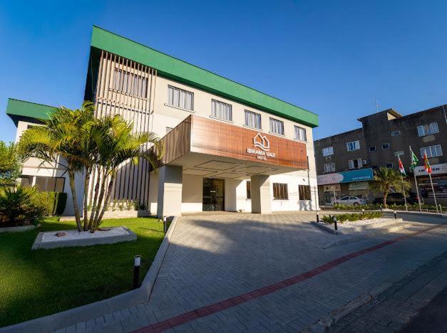 a building with a palm tree in front of it at Ibirama Vale Hotel in Ibirama