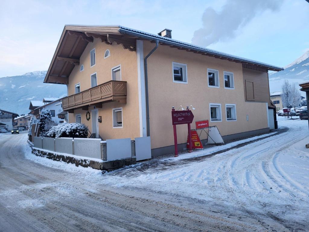 a building on a snow covered street in front at Ferienwohnung-Gerti in Uderns