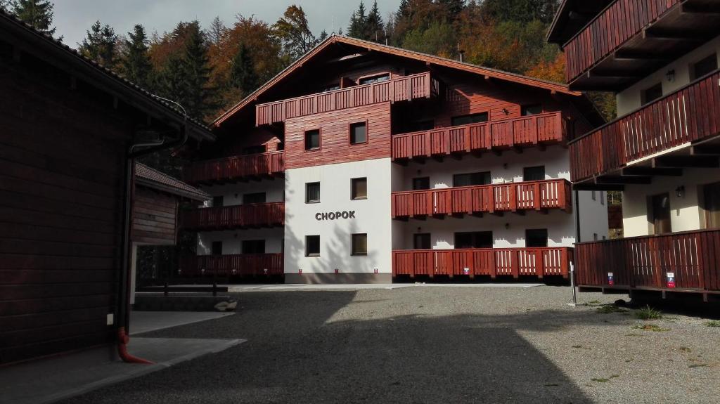 a building with red balconies on the side of it at Apartmán Chopok juh Monika in Tale
