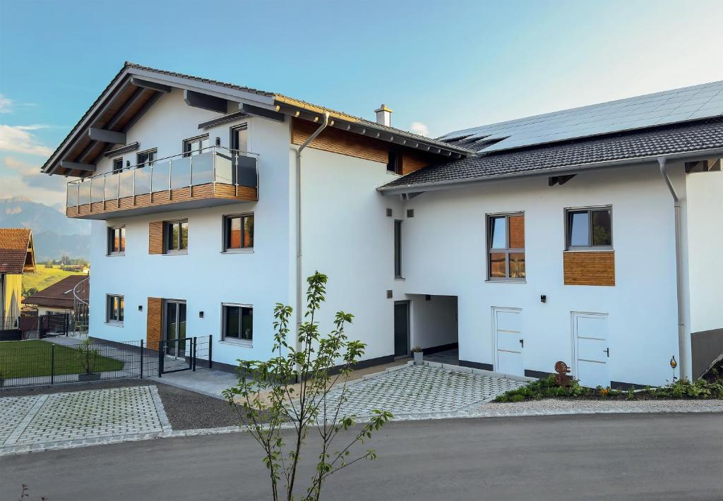 a white house with a balcony on it at Beim Huber in Hopferau