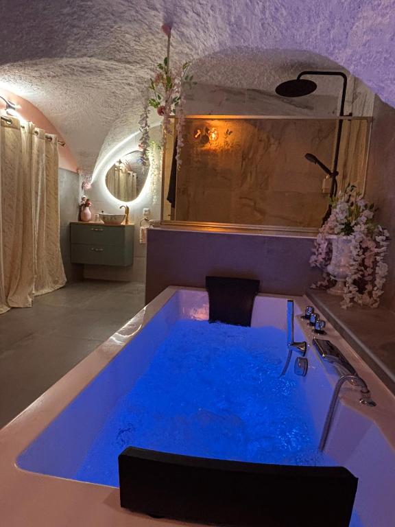 a large blue tub in a bathroom with a sink at La suite des cœurs cachés in Valserres