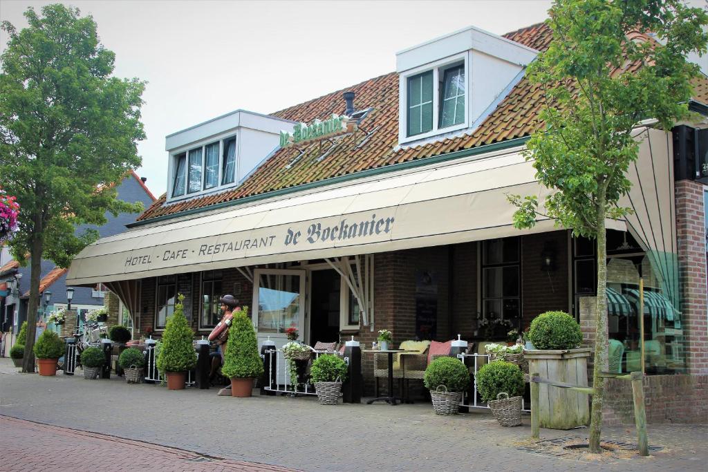 a restaurant with tables and chairs in front of a building at Hotel Restaurant de Boekanier in Vrouwenpolder