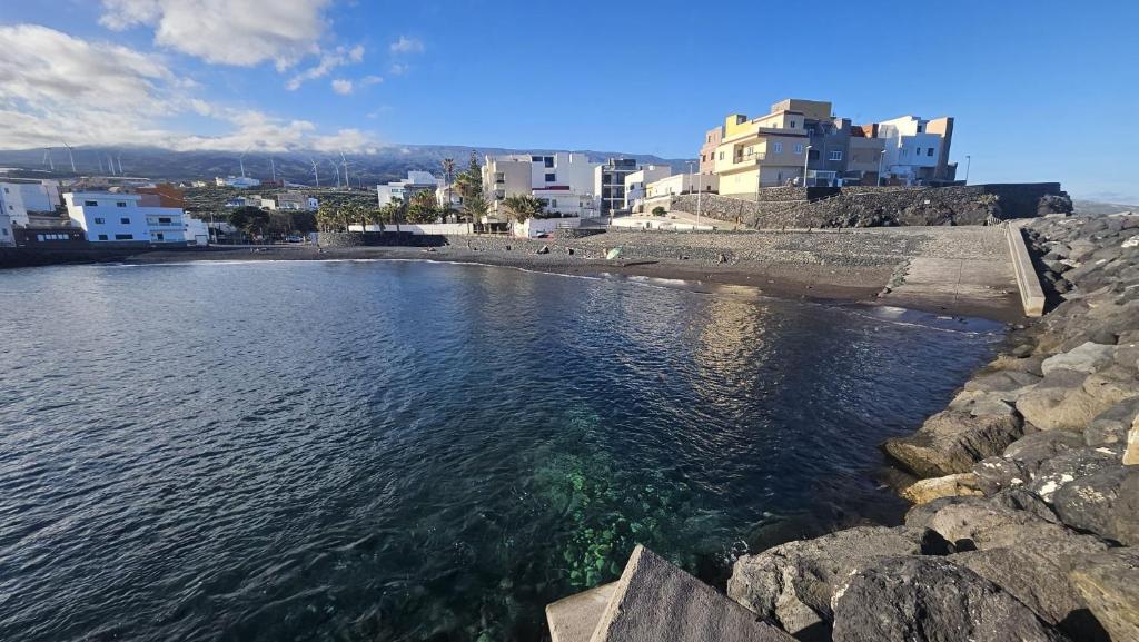 a large body of water with buildings in the background at La Perlita in Las Eras