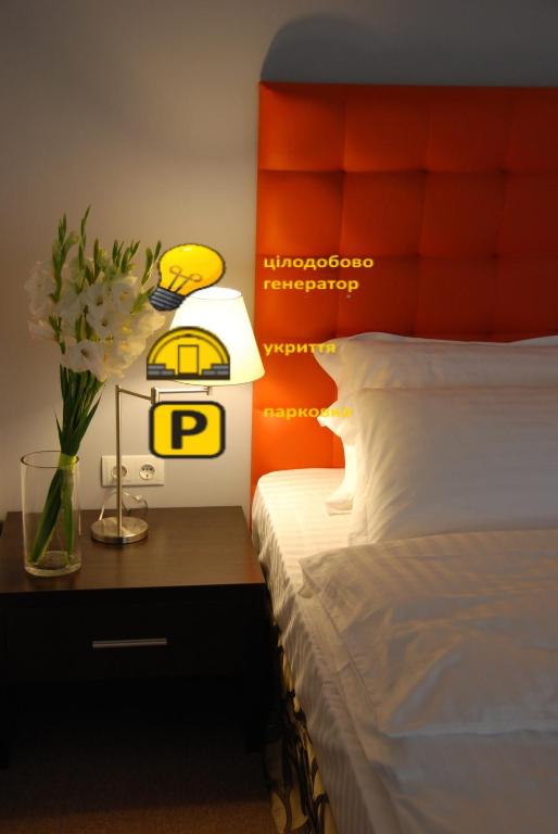 a bedroom with a bed and a table with a lamp at Bontiak Hotel in Kyiv