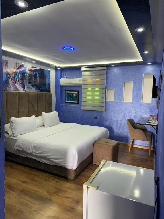 a bedroom with a bed and a desk with a chair at Hotel Annasr in Chefchaouen
