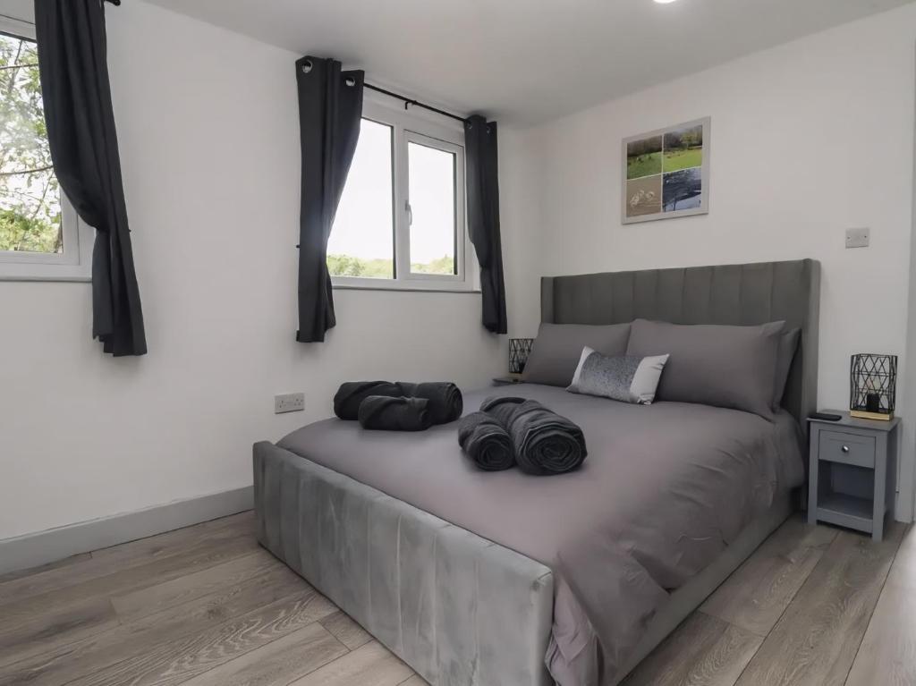 a bedroom with a large bed with two bags on it at The Cabin - Private Car Park with CCTV - Fast WiFi - Peaceful Retreat with Views for Business or Couples in Oldbury