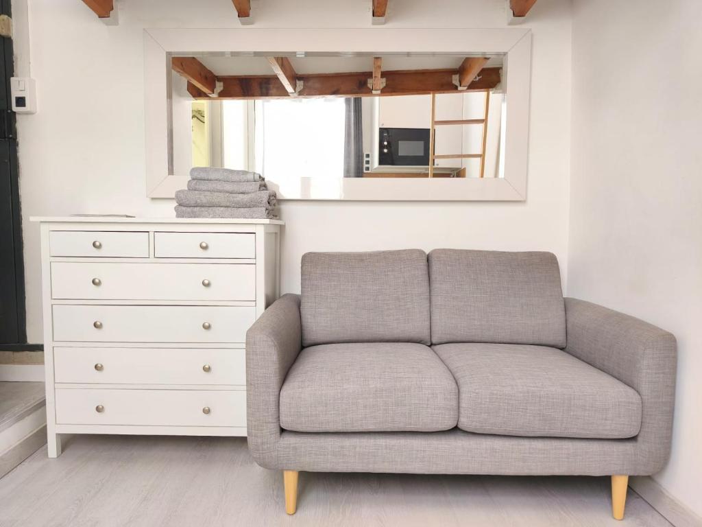 a couch in a room with a dresser and a mirror at Studio lumineux Avignon centre, proche de tout in Avignon