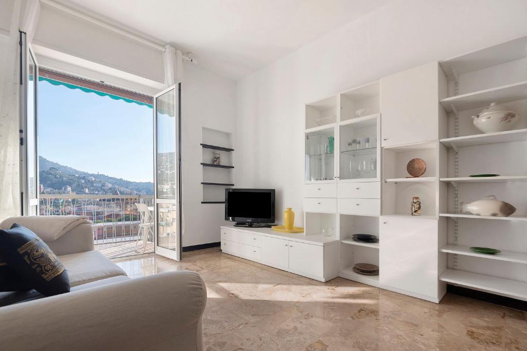 a white living room with a tv and a couch at Maison Giovanna with garage parking in Rapallo