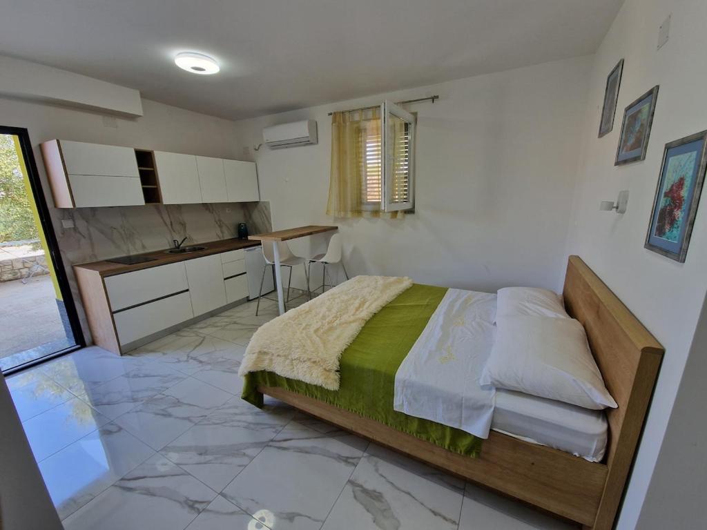a bedroom with a large bed and a kitchen at Sunce 5 in Vrbnik