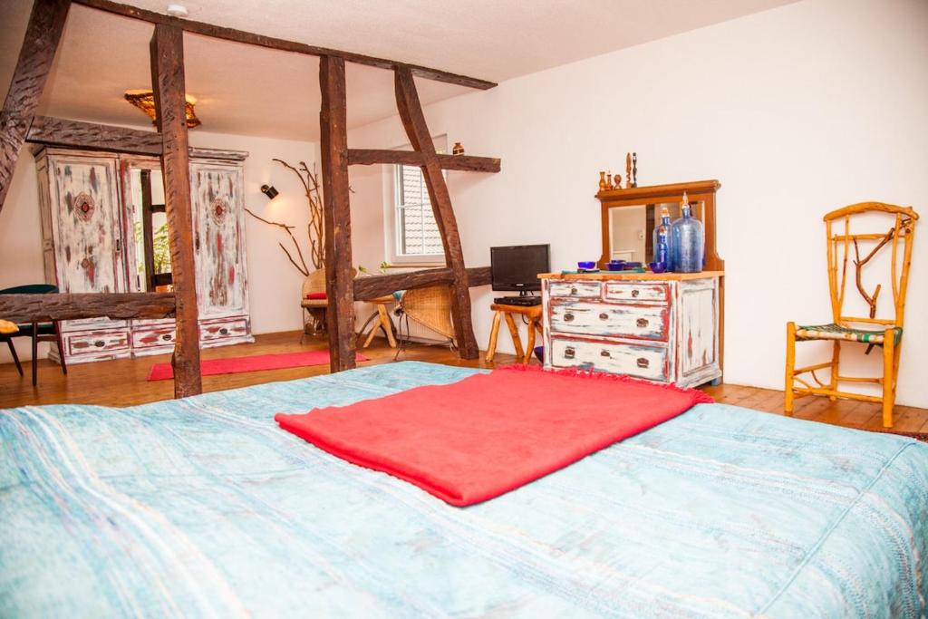 a bedroom with a large bed with a red blanket on it at Canoe Welcome in Hattingen