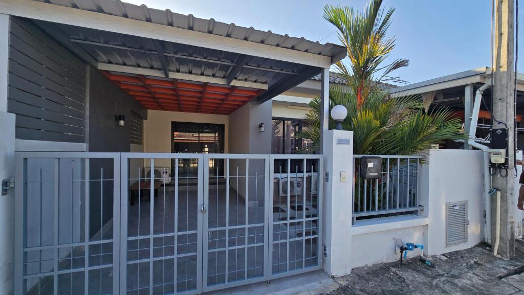 a house with a gate and a fence at Joyful House Naiyang beach in Thalang