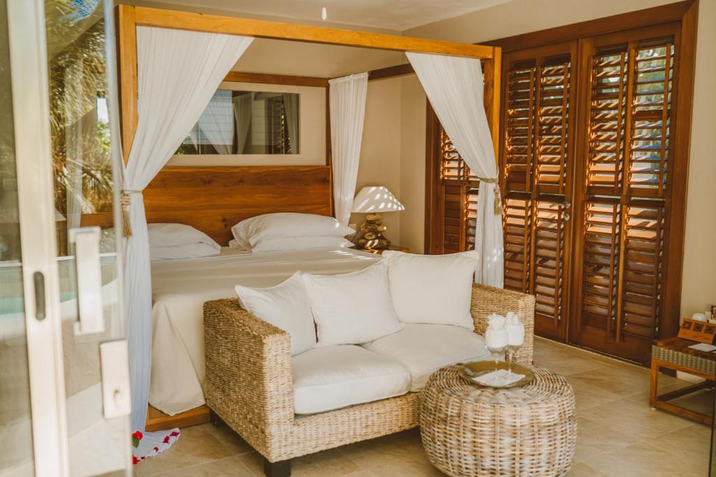 a bedroom with a bed and a white couch at Secret Garden Hideaway in Balcheil