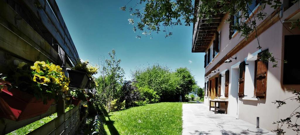 an alley between two buildings with flowers on the side at Logis Hôtel - Auberge les Clarines in Le Châtelard