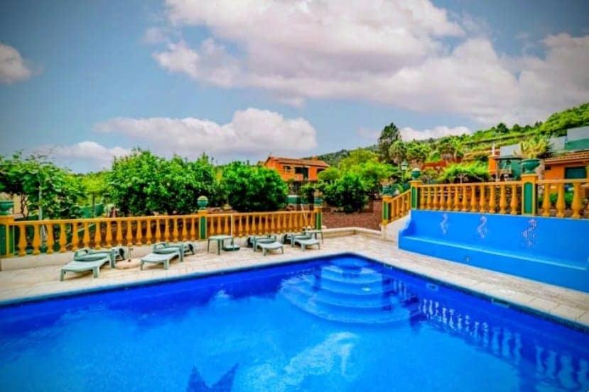 a large swimming pool with a wooden fence around it at Tropical Paradice Villa in Icod de los Vinos