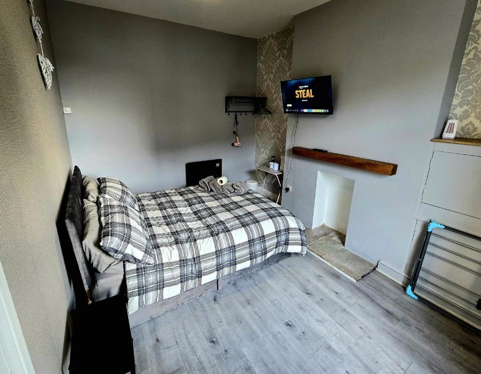 a bedroom with a bed and a clock on the wall at Cog Lane House in Burnley