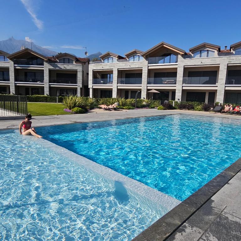 a man sitting in a swimming pool in a building at Dany Lodge Lago di Como in Colico