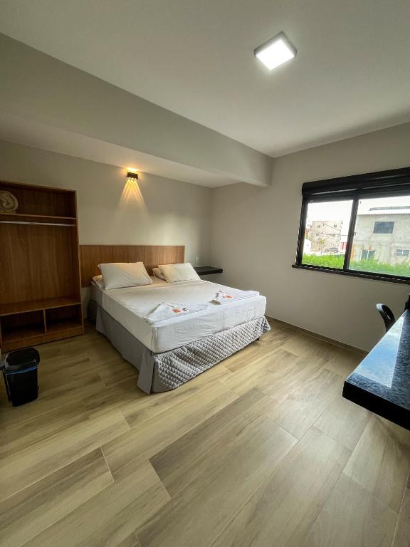 a bedroom with two beds and a window at Pousada Arco Iris Fortaleza in Fortaleza