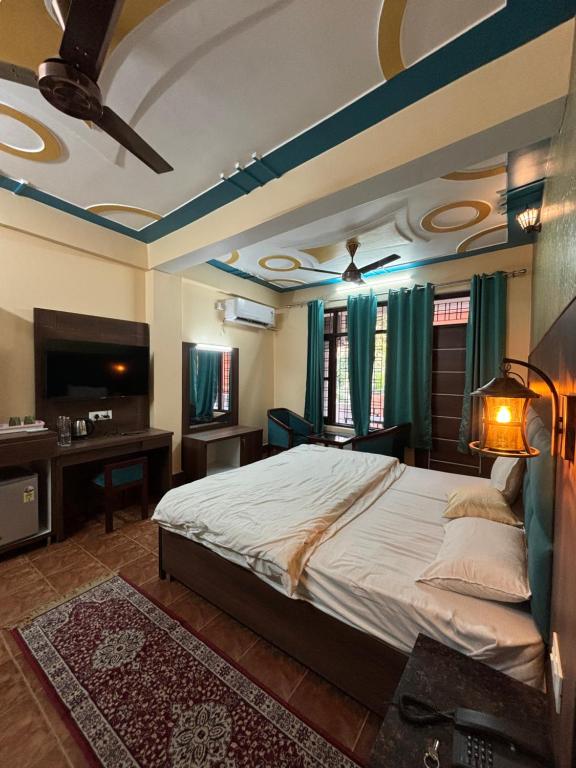 a bedroom with a large bed and a television at Himalayan Stayz in Rishīkesh