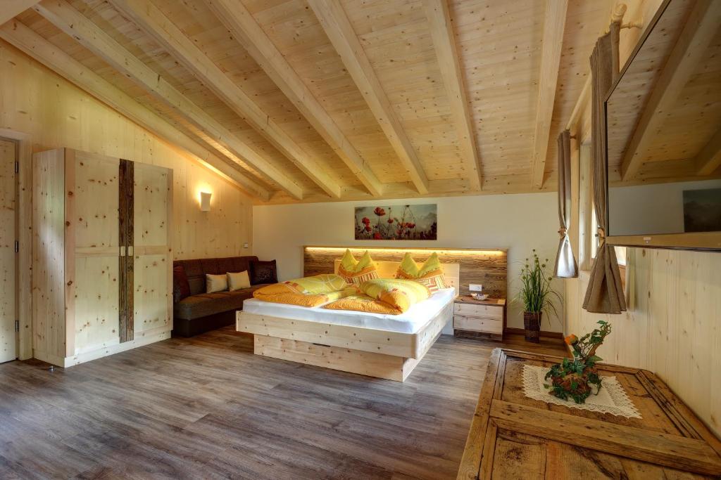 a bedroom with a large bed and a wooden ceiling at Lechnerhof in Lutago