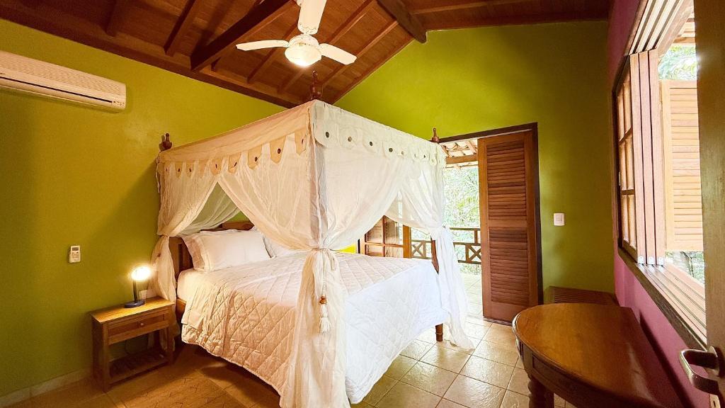 a bedroom with a white bed with a canopy at Pousada Taman Baru in Pirenópolis