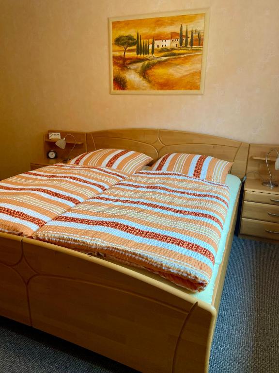 a bed in a bedroom with a picture on the wall at B&B Pension-Schönheim in Monzingen
