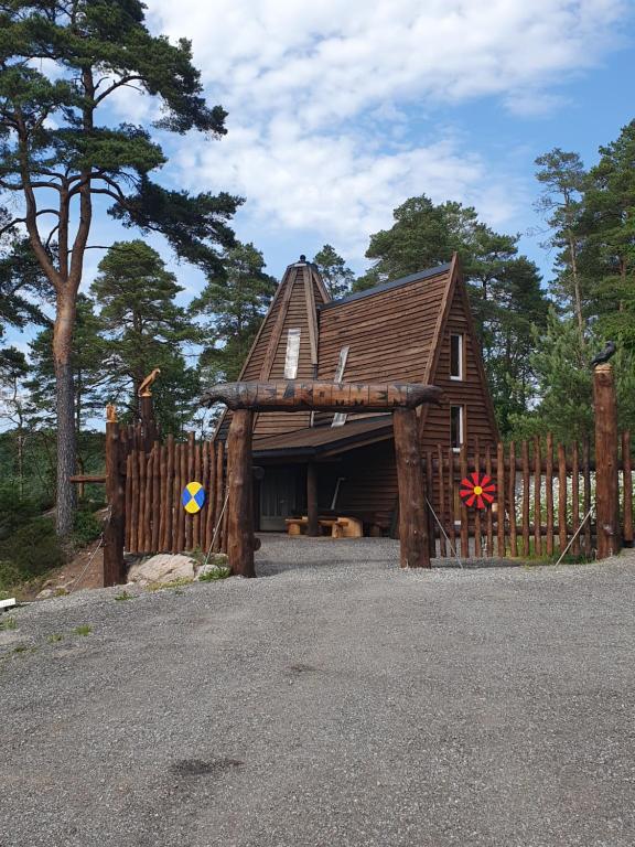 a wooden house with a fence in front of it at Gluba Lavvo in Harkmark