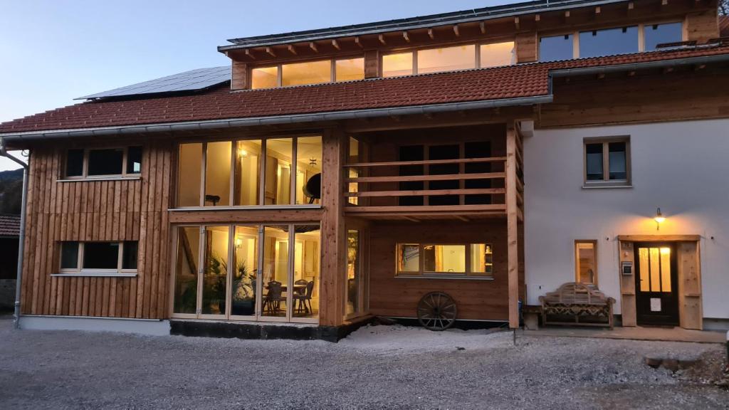 a house with large glass windows on the side of it at Doppelzimmer in Boutique Hostel in Pfronten