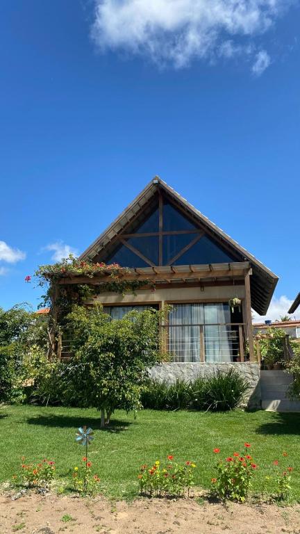 a house with a roof with flowers in the yard at Chalé I - Village da Serra in Serra de São Bento