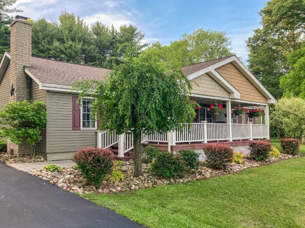 a house with a porch with flowers on it at 15 off Summer Special - Wifi - Pet Friendly in Sigel