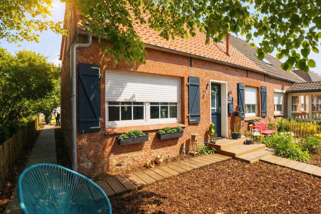a brick house with a window and a patio at Huus ant Dörpsdiek in Krummhörn