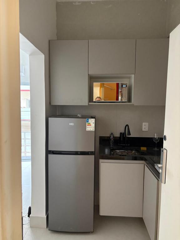a kitchen with a white refrigerator and a sink at Kit Gonzaga Santos in Santos